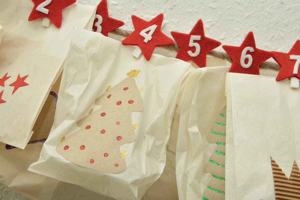 calendario de adviento mostrando dÃ­as 2 al 7 en estrellas rojas sosteniendo bolsas con diseÃ±os de Ã¡rboles navideÃ±os, para ilustrar que para el marketing en facebook las fechas decembrinas van mÃ¡s allÃ¡ del 24 de diciembre