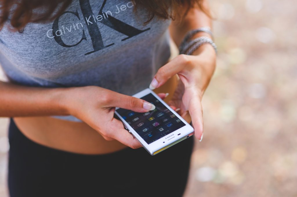 chica utilizando un smartphone, en las campaÃ±as de marketing en facebook es muy importante enfocarse en los dispositivos mÃ³viles